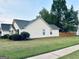 The side view of the home showcases its light yellow siding and dark gray roof at 486 Village Cir, Stockbridge, GA 30281