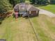 Aerial view of a brick home with a large yard, deck, and a fenced in backyard at 611 Bernhard Rd, Fayetteville, GA 30215