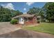 Charming red brick home featuring lush landscaping, a driveway, and a well-manicured lawn at 611 Bernhard Rd, Fayetteville, GA 30215