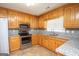 Spacious kitchen with granite countertops, wooden cabinets, and stainless steel appliances at 611 Bernhard Rd, Fayetteville, GA 30215