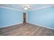 Light-filled bedroom features wood-look flooring, blue walls, and white trim at 611 Bernhard Rd, Fayetteville, GA 30215