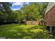 Lush backyard with a wood fence and view of a brick home's exterior at 3260 Russell St, Hapeville, GA 30354