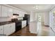Modern kitchen with white cabinets, black appliances, and an island sink at 3260 Russell St, Hapeville, GA 30354