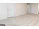 A comfortable bedroom has neutral carpet and paint, with two doors and a view into the hallway at 244 Oliver Dr, Locust Grove, GA 30248