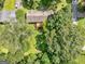 A home with a wooden deck is nestled among mature trees and lush green lawns in an aerial view at 100 Homestead Pl, Rex, GA 30273