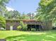 Spacious backyard featuring a brick home, wooden deck, walkout basement, and verdant lawn at 100 Homestead Pl, Rex, GA 30273