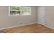 Bedroom featuring hardwood floors, neutral walls, and a sunlit window providing ample lighting at 100 Homestead Pl, Rex, GA 30273