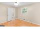 Comfortable bedroom featuring hardwood floors, a window, and an attached bathroom at 100 Homestead Pl, Rex, GA 30273