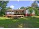 Backyard view with a large wooden deck featuring stairs leading to the spacious green lawn at 315 Charlotte Blvd, Stockbridge, GA 30281