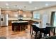 Open-concept kitchen features an island with bar seating, stainless appliances, and adjacent dining area at 9108 Alden Dr, Locust Grove, GA 30248
