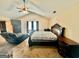 Main bedroom with a vaulted ceiling, ceiling fan, large bed, and relaxing chaise lounge at 9108 Alden Dr, Locust Grove, GA 30248