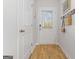 Bright entryway featuring wood-look flooring, white walls, and a stylish coat rack with a woven basket at 122 Meadowview Dr # 11, Temple, GA 30179
