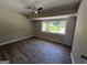 A bedroom with wood-look flooring, natural light from a large window, and neutral paint at 421 Safari Cir, Stone Mountain, GA 30083