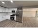 Bright kitchen features stainless steel appliances and white cabinetry, seamlessly connecting to a sun-filled living area at 421 Safari Cir, Stone Mountain, GA 30083