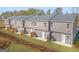 Backyard view of townhomes featuring fencing, patios, and green lawns at 123 Meadowview Dr # 15, Temple, GA 30179