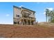 Rear view of the home showing a raised deck and walkout basement on a sloped lot at 7530 W Homer Dr, Cumming, GA 30028
