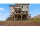 Rear view of home featuring a raised deck with stairs down to the yard and a walkout basement at 7530 W Homer Dr, Cumming, GA 30028