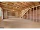 Unfinished basement with wood framing, stairs, insulation, and natural light from windows at 7530 W Homer Dr, Cumming, GA 30028
