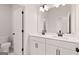 Modern bathroom with double sink vanity, white cabinets, and matte black hardware at 7530 W Homer Dr, Cumming, GA 30028