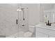 Modern bathroom with a glass-enclosed shower featuring marble tile and white vanity at 7530 W Homer Dr, Cumming, GA 30028