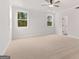 Spacious bedroom with two windows, neutral carpet, ceiling fan, and a walk-in closet at 7530 W Homer Dr, Cumming, GA 30028
