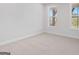 Clean bedroom with carpet, white walls, white trim, and view of the outside at 7530 W Homer Dr, Cumming, GA 30028