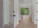 Bright entryway with light hardwood floors leading into a living space with a view of the backyard deck at 7530 W Homer Dr, Cumming, GA 30028