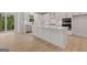 Bright, open-concept kitchen features a large island, stainless steel appliances, and access to a balcony at 7530 W Homer Dr, Cumming, GA 30028