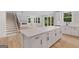 Spacious open-concept kitchen featuring a large island with white countertop and easy access to a staircase at 7530 W Homer Dr, Cumming, GA 30028