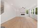 Bright living room featuring a fireplace, light wood floors, and large windows at 7530 W Homer Dr, Cumming, GA 30028
