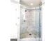 Sleek marble shower with glass door enclosure and a built-in bench at 910 Lilac Arbor Rd, Dacula, GA 30019