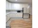 Bright kitchen features white cabinetry, stainless steel appliances, and hardwood floors at 910 Lilac Arbor Rd, Dacula, GA 30019