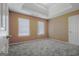 Bedroom features neutral carpet, two windows, neutral walls, and a tray ceiling at 204 Eleanor Court, Stockbridge, GA 30281