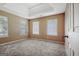 Bedroom featuring neutral carpeting, three windows, and tray ceiling at 204 Eleanor Court, Stockbridge, GA 30281