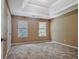 Spacious bedroom with carpet floors, two windows, and a tray ceiling at 204 Eleanor Court, Stockbridge, GA 30281