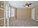 Cozy carpeted room with a ceiling fan, a window, and a door that opens to another room at 204 Eleanor Court, Stockbridge, GA 30281