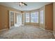 Carpeted bonus room with many windows and an open doorway leading to the main entrance at 204 Eleanor Court, Stockbridge, GA 30281