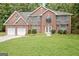 Charming two-story brick home with a well-manicured lawn and attached two car garage at 204 Eleanor Court, Stockbridge, GA 30281