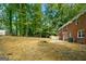 Large backyard with a red brick house, shed, and perimeter fencing at 1783 Cheyenne Trl, Jonesboro, GA 30236