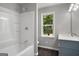 Bathroom with tub/shower, blue vanity, and window view offering natural light at 1783 Cheyenne Trl, Jonesboro, GA 30236