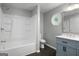 The bathroom offers tub/shower combo, gray walls, white trim and a blue vanity with marble countertop at 1783 Cheyenne Trl, Jonesboro, GA 30236