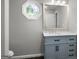 Bathroom features vanity with marble countertop, designer mirror, gray walls, white trim and stained glass window at 1783 Cheyenne Trl, Jonesboro, GA 30236