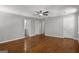 Large bedroom featuring hardwood floors, a ceiling fan, and multiple closets and doors at 1783 Cheyenne Trl, Jonesboro, GA 30236