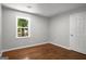 Cozy bedroom featuring hardwood floors, a window offering natural light, and a closet door at 1783 Cheyenne Trl, Jonesboro, GA 30236