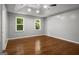 A bedroom includes hardwood floors, gray walls, white trim, a tray ceiling and windows with natural light at 1783 Cheyenne Trl, Jonesboro, GA 30236