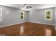 Spacious bedroom with hardwood floors, two windows, a ceiling fan, and neutral paint at 1783 Cheyenne Trl, Jonesboro, GA 30236