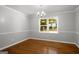 A dining room features hardwood floors, gray walls, white trim and a modern chandelier above a table location at 1783 Cheyenne Trl, Jonesboro, GA 30236