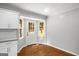 A kitchen nook features hardwood floors, gray walls, white trim and an exterior door for back yard access at 1783 Cheyenne Trl, Jonesboro, GA 30236
