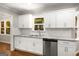 Well-lit kitchen with granite countertops, stainless dishwasher, and white cabinets at 1783 Cheyenne Trl, Jonesboro, GA 30236