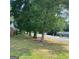 Expansive front yard with mature trees lining the street, offering a serene and welcoming atmosphere at 213 Whipporwill Way, Riverdale, GA 30274